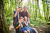Family at rope swing in woods