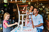 Family painting chair in workshop