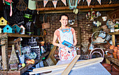 Woman with power sander in workshop
