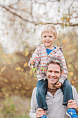 Father carrying toddler son on shoulders