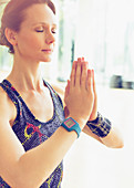 Woman practicing yoga with hands clasped