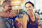 Smiling man and woman resting at gym