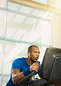 Determined man on elliptical trainer