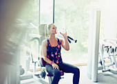 Woman drinking water in gym