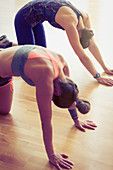 Women doing cat pose in exercise class