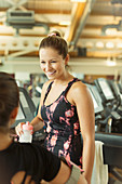 Smiling women talking at gym