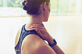 Woman rubbing neck at gym