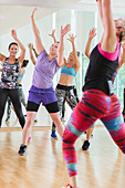 Women with arms raised in exercise class