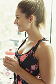 Smiling woman drinking water at gym