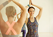 Woman with hands overhead in yoga class
