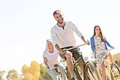 Smiling young man bike riding with women