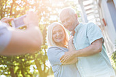 Man photographing senior couple outdoors