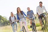 Happy family bike riding in sunny field