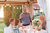 Senior man toasting family with red wine