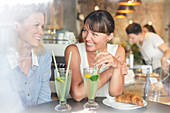 Women drinking lemonade at cafe table