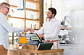 Customer paying cafe worker