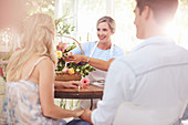 Florist discussing flowers with couple