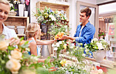 Florist giving man bouquet at flower shop