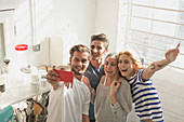 Adult roommates taking selfie in kitchen