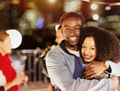 Young couple hugging at party