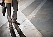 Businessman standing on sunny pavement
