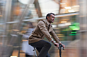 Corporate businessman riding bicycle
