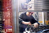 Worker repairing machinery in factory