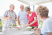 Senior couples preparing patio lunch