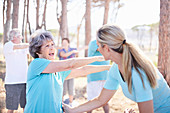 Yoga instructor guiding senior woman