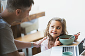 Father and daughter eating breakfast