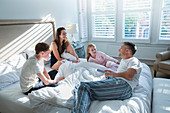 Family in pajamas relaxing on bed