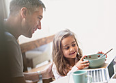 Father and daughter eating breakfast