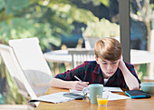 Boy doing math homework at dining table
