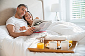 Smiling couple reading newspaper