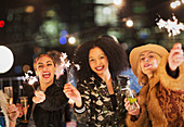 Women waving sparklers at party