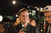Smiling young man drinking beer