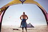 Man preparing to kiteboard on sunny beach