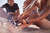 Woman fastening kiteboard to feet