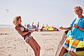 Couple preparing kiteboarding equipment