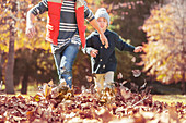 Boys running in autumn leaves