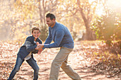 Playful father and son on path in woods