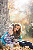 Mother and son at tree trunk