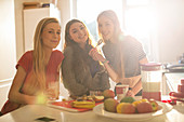 Girls eating in sunny kitchen