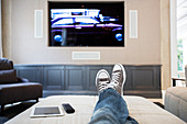 Woman's feet on ottoman watching TV