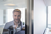 Businessman at window in conference room