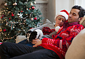 Couple on sofa next to Christmas tree