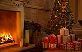 Christmas tree and gifts near fireplace
