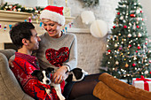 Couple with dog near Christmas tree