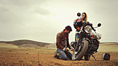 Young couple repairing motorcycle
