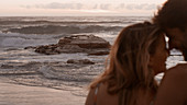 Couple cuddling on ocean beach